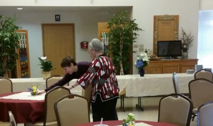 roxanne and anne dorsback set up tables in the welcoming space